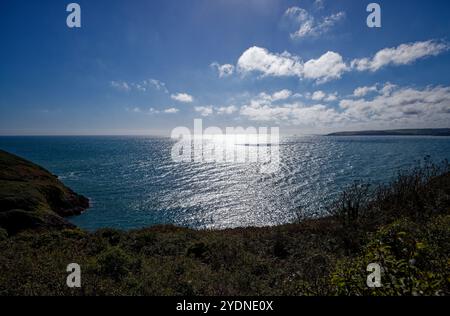Silbriges Sonnenlicht glitzert auf der Weite der Mevagissey Bay in der Nähe von Pentewan, St Austell, Cornwall. Stockfoto