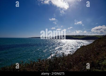 Die Sonne glitzert auf dem blauen Wasser der Mevagissey Bay in Pentewan Sands, St Austell, Cornwall. Stockfoto
