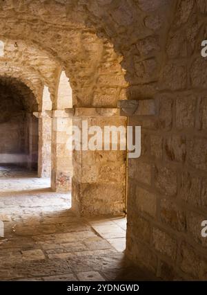 Schöner Backsteinbogen mit zurückziehendem Pfad in einer Kirche in Jerusalem Stockfoto