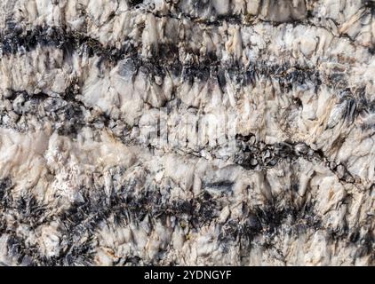 Einzigartige Mineralmuster zeigen markante Strukturen in Felsen, die von Sonnenlicht beleuchtet werden und die Kunstfertigkeit der Natur zum Ausdruck bringen. Stockfoto