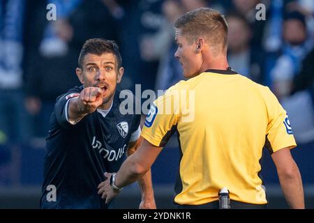 Bochum, Deutschland. Oktober 2024. Fußball: Bundesliga, VfL Bochum - Bayern München, Spieltag 8, Vonovia Ruhrstadion: Bochumer Anthony Losilla (l) beschwert sich bei Schiedsrichter Florian Exner. Hinweis: David Inderlied/dpa - WICHTIGER HINWEIS: Gemäß den Vorschriften der DFL Deutschen Fußball-Liga und des DFB Deutschen Fußball-Bundes ist es verboten, im Stadion und/oder des Spiels aufgenommene Fotografien in Form von sequenziellen Bildern und/oder videoähnlichen Fotoserien zu verwenden oder zu verwenden./dpa/Alamy Live News Stockfoto