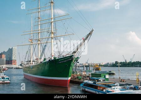 Das alte Segelschiff Rickmer Rickmers am Elbufer mit der Elbphilharmonie im Hintergrund der Stadt Hamburg. Stockfoto