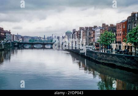 Bachelors Walk, Dublin, Irland 1957, von der Halfpenny Bridge aus gesehen, mit Autos der damaligen Zeit, den vier Courts auf der rechten Seite und Guinness’s auf der linken Seite in der Ferne und dem Fluss Liffey dominiert. Stockfoto