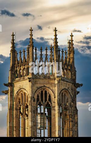 Eine Nahaufnahme der Spitze eines Steinturms mit einer Reihe von Spitzbögen und Türmen vor einem bewölkten Himmel in York, North Yorkshire, Großbritannien. Stockfoto