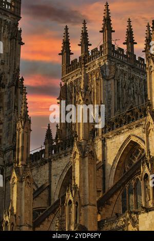 Eine aus nächster Nähe erscheinende Steinkathedrale vor einem Sonnenuntergang. Das Bild konzentriert sich auf die komplizierten Details der gotischen Architektur, einschließlich spitzer Ar Stockfoto