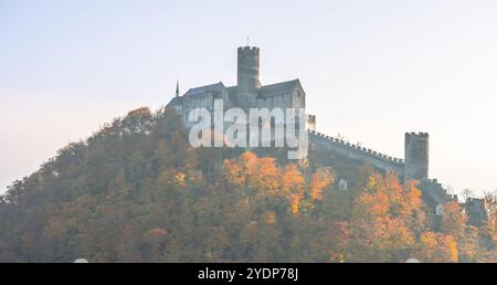 Der Herbst verwandelt die Burg Bezdez in einen lebendigen Anblick, wo die gotische Architektur stolz inmitten der bunten Bäume steht und die reiche Geschichte der tschechischen Länder widerspiegelt. Stockfoto