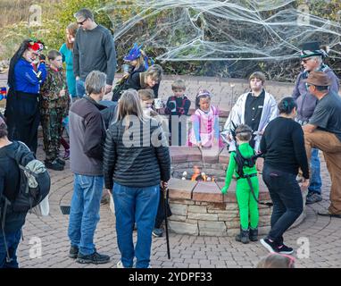 Lakewood, Colorado – Familien genießen die Veranstaltung vor Halloween im Bear Creek Lake Park, bei der Marshmallows um ein Feuer toben. Stockfoto