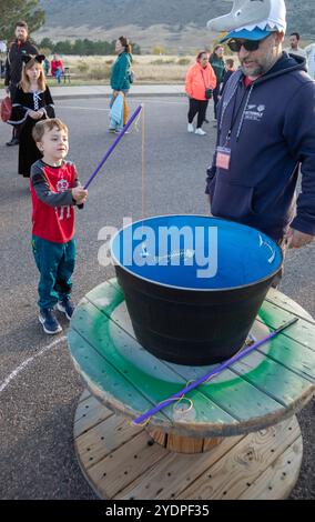 Lakewood, Colorado – Familien genießen den Haunted Trail vor Halloween im Bear Creek Lake Park. Ein Junge fischt in einer Fischschale um Preise. Stockfoto