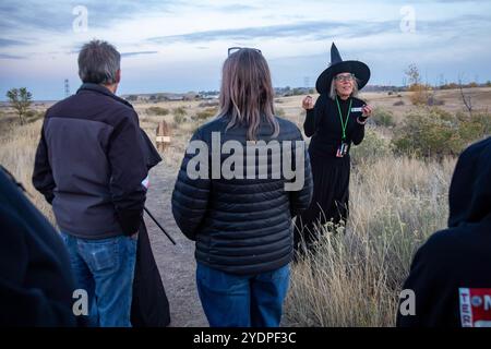 Lakewood, Colorado – Familien genießen den Haunted Trail vor Halloween im Bear Creek Lake Park. Ein Freiwilliger im Park, verkleidet als Hexe, führt auf eine tr Stockfoto