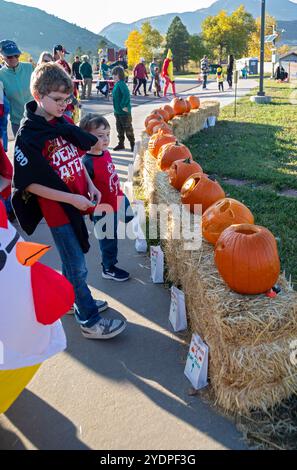 Lakewood, Colorado – Familien genießen den Haunted Trail vor Halloween im Bear Creek Lake Park. Zwei Jungs überlegen, für welchen Kürbis sie stimmen sollen Stockfoto