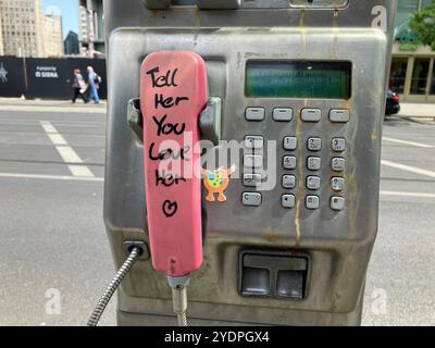 Ein Münztelefon mit der Nachricht „Sag ihr, dass du sie liebst“ auf dem pinkfarbenen Receiver in der Nähe des Alexanderplatzes. Mitte, Berlin, Deutschland. Mai 2023. Stockfoto