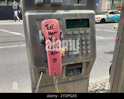 Ein Münztelefon mit der Nachricht „Sag ihr, dass du sie liebst“ auf dem pinkfarbenen Receiver in der Nähe des Alexanderplatzes. Mitte, Berlin, Deutschland. Mai 2023. Stockfoto