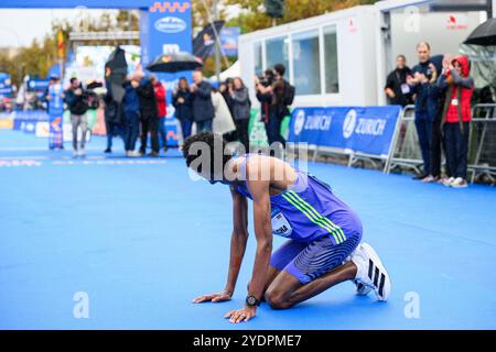 Der äthiopische Olympiasiäufer Yomif Kejelcha kniete am 24. Oktober nach dem neuen Weltrekord im Halbmarathon in Valencia an der Ziellinie Stockfoto