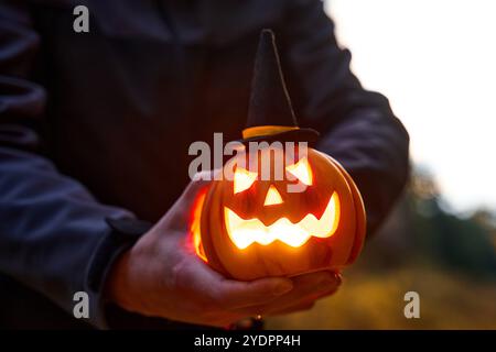 Bayern, Deutschland - 27. Oktober 2024: Mann mit Halloween Kürbislaterne in der Dunkelheit im Herbst *** Mann mit Halloween-Kürbis-Laterne in der Dunkelheit im Herbst Stockfoto