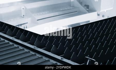 Glänzendes Metallblech liegt auf dem Tisch einer industriellen Laserschneidemaschine Stockfoto