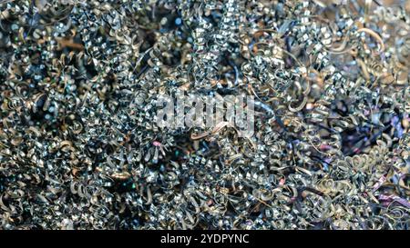 Ein Haufen Metallspäne mit metallischem Glanz. Die Späne sind verstreut und scheinen aus einem Schleifprozess zu stammen Stockfoto