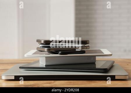 Stapel moderner Gadgets auf Holztisch in der Werkstatt Stockfoto