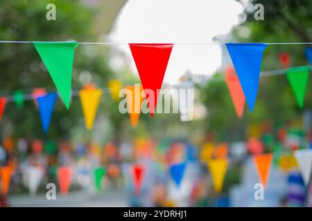 Dekorative mehrfarbige Dreiecksfahnen vor dem Hintergrund beim Festival in Thailand. Stockfoto