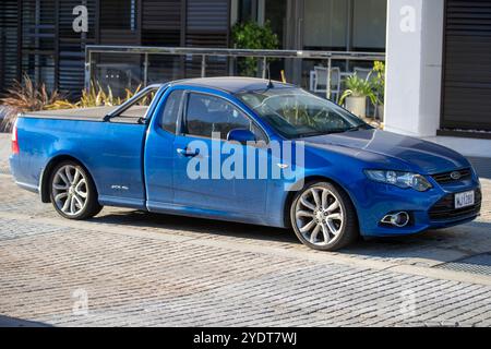 Ein blaues Nutzfahrzeug des Typs Ford Falcon XR6 Turbo, das auf einer Kopfsteinpflasterstraße geparkt ist und ein elegantes Außendesign und ein XR6-Emblem aufweist. Stockfoto