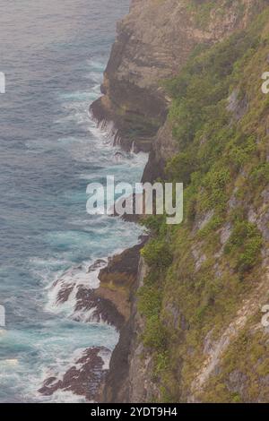 Von oben krachen türkisfarbene Wellen sanft auf den weichen Sand von Kelingking Beach in Nusa Penida, Bali. Stockfoto