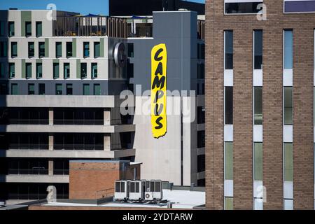 Dieses Bild zeigt ein modernes Campus-Gebäude mit einem großen gelben „CAMPUS“-Schild an der Fassade Stockfoto