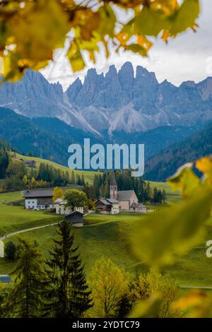 Ein ruhiges Dorf in den Dolomiten ist voller herbstlicher Farben, eingerahmt von hohen Gipfeln. Santa Maddalena Val di Funes Italien Stockfoto