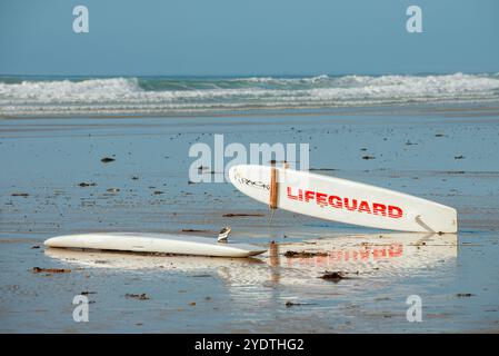 An einem Sandstrand liegt ein Rettungsschirm an, der für die Rettung von Ozeanen bereit ist. Stockfoto