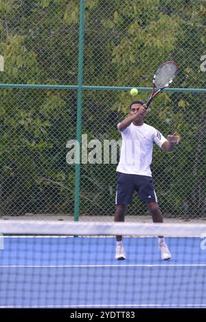 Randheli, Malediven - 24. Februar 2014: Ein asiatischer Indianer spielt Tennis auf einem tropisch blauen Tennisplatz. Stockfoto