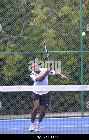 Randheli, Malediven - 24. Februar 2014: Ein asiatischer Indianer spielt Tennis auf einem tropisch blauen Tennisplatz. Stockfoto