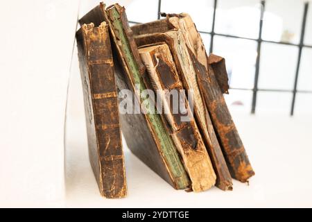 Eine Sammlung alter verwitterter Bücher mit gerissenen Rückseiten und losen Seiten Stockfoto