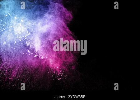 Abstrakte mehrfarbige Pulverexplosion auf schwarzem Hintergrund. Freeze-Bewegung von bunten Staubpartikeln Spritzen. Lackiertes Holi Stockfoto