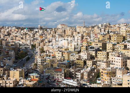 Nordöstliches Viertel mit der jordanischen Flagge auf einem 126 m langen Fahnenmast vor dem Raghadan-Palast, Blick von der Spitze des Zitadellen-Hügels in Amman, Jordanien Stockfoto