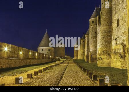 Cite de Carcassonne ist eine mittelalterliche Zitadelle in der französischen Stadt Carcassonne. Türme und Mauern am Abend Stockfoto