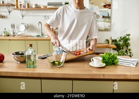 Ein junger Mann hackt gekonnt Gemüse und kreiert einen lebendigen Salat in einer schicken Küche. Stockfoto