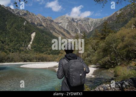 Junger männlicher Tourist, der nach Kamikochi, Nagano in Japan reist. Alleinreisende Rucksacktouristen mit Blick auf die Berge der alpen Stockfoto