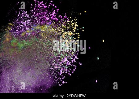 Mehrfarbige Pulverexplosion auf schwarzem Hintergrund. Farbige Staubwolke auf dunklem Hintergrund. Bunte Partikel auf dem Hintergrund Stockfoto