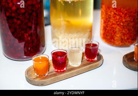 Der Barkeeper bereitet farbenfrohe alkoholische Shots aus hausgemachten Zutaten vor Stockfoto