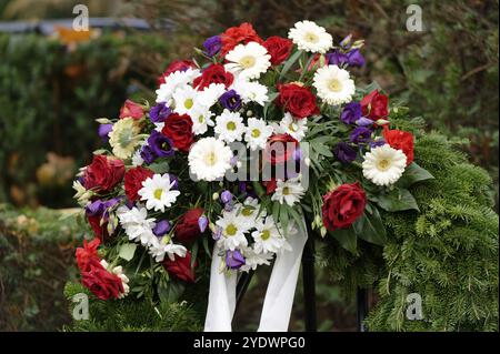 Trauerkranz mit bunten Blumen und weißem Band Stockfoto
