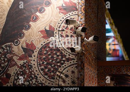 Neu Delhi, Indien. Oktober 2024. Sicherheitskameras hängen an einer Wand mit indischen Mustern bei einer Veranstaltung. Quelle: Sebastian Christoph Gollnow/dpa/Alamy Live News Stockfoto