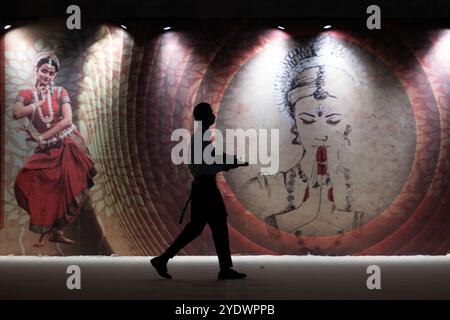 Neu Delhi, Indien. Oktober 2024. Ein Kellner läuft vor einer Wand mit indischen Bildern und Mustern bei einer Veranstaltung. Quelle: Sebastian Christoph Gollnow/dpa/Alamy Live News Stockfoto