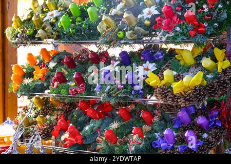 Adventskränze auf einem Markt im Freien. Weihnachtswaren, Adventskränze auf dem Adventmarkt. Weihnachtskerzen auf dem Markt im Freien. Stockfoto