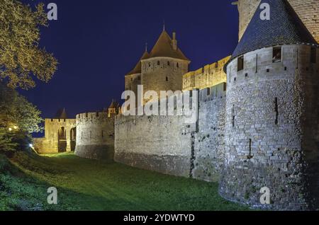 Cite de Carcassonne ist eine mittelalterliche Zitadelle in der französischen Stadt Carcassonne. Türme und Mauern am Abend Stockfoto