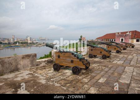 Historische Bronzekanonen und Innenstadt auf der anderen Seite der Bucht, Castillo del Morro, Bahia de la Habana, Kuba Stockfoto