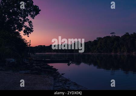 Ruhiger Sonnenaufgang in Stoelmans Eiland, Suriname. Der Himmel leuchtet in sanften violetten und orangen Tönen und empfängt die Wärme der Sonne. Stockfoto