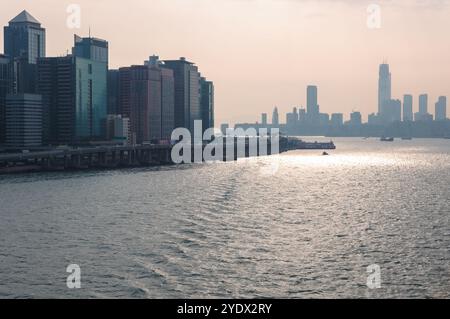 Hongkong, China - 27. April 2009: Ein ruhiger Blick auf die Skyline und die Uferpromenade der Stadt bei Sonnenuntergang. Stockfoto