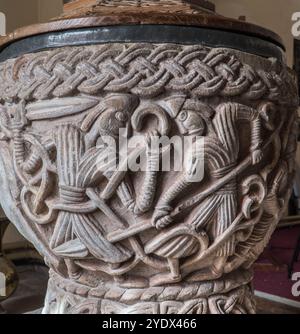 Norman Font aus dem 12. Jahrhundert, die zwei kämpfende Männer in denselben Gewändern darstellt, St Mary Magdalene Church Eardisley Herefordshire England Großbritannien 2. September Stockfoto