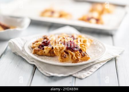 Süßes Dessertgebäck aus Blätterteig mit Erdbeermarmelade gefüllt mit karamelisiertem Apfel. Stockfoto