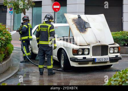 Der weiße 1980er Bentley brannte den Motorraum aus, die Motorhaube war offen und die Polizei und die Feuerwehr waren in einer Straße im Stadtzentrum von Madrid, Spanien Stockfoto