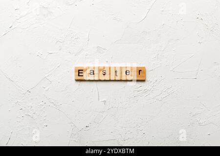 Osterwort auf Holzblock geschrieben. Ostertext auf Zementtisch für Ihren Entwurf, Konzept. Stockfoto