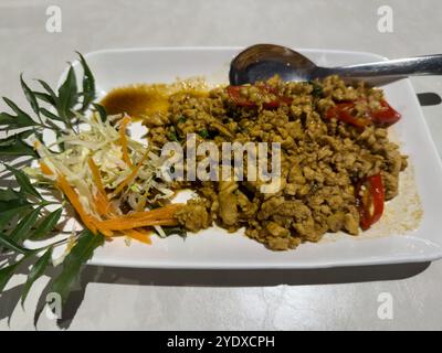 Gebratenes thailändisches Hackfleisch mit Basilikumblättern und roten Chilis. Thailändische Schweinezubereitung oder asiatische Gerichte. Stockfoto